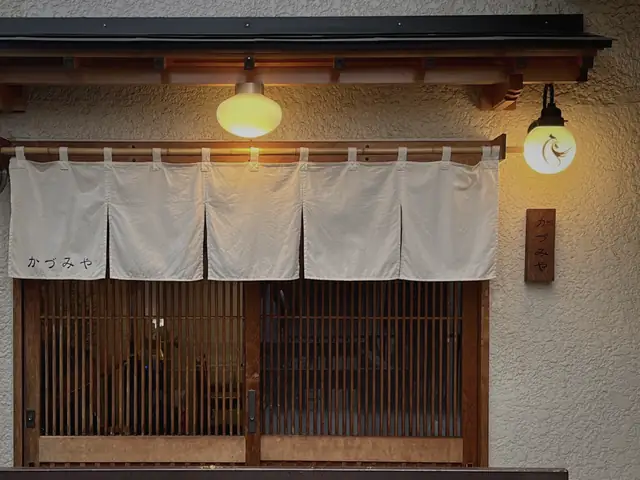 サンルートビル2階の店先。白い暖簾と格子戸