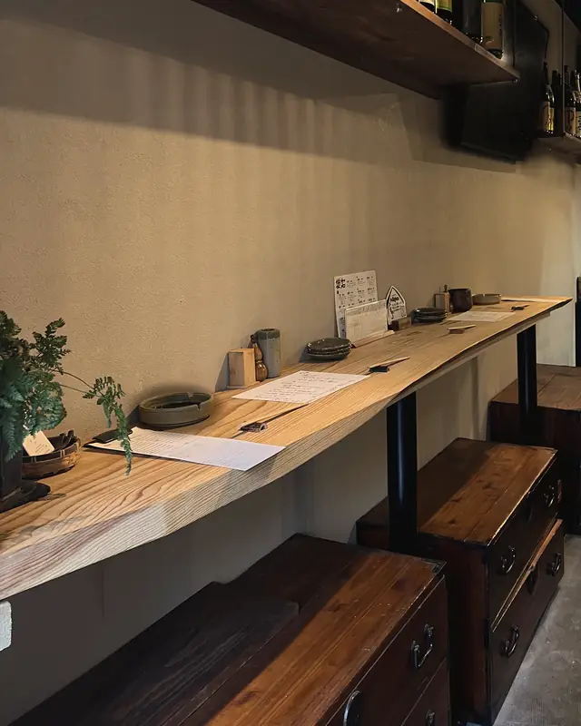 壁沿いの木のカウンター席と箪笥の腰掛け